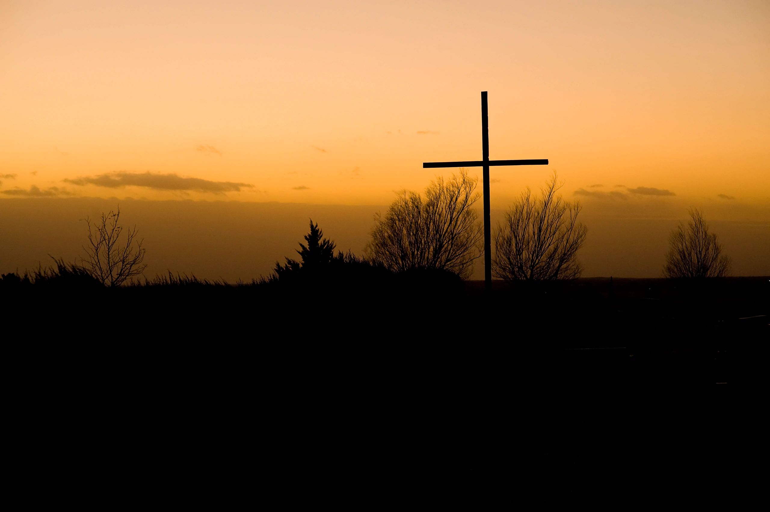 Cross silhouette at sunrise (symbolic)